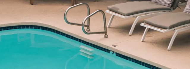 two gray lounge chairs beside swimming pool